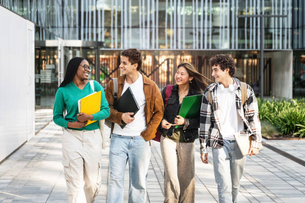 istock Happy student friends walking on university campus, chatting and laughing outdoors after classes 2153425043