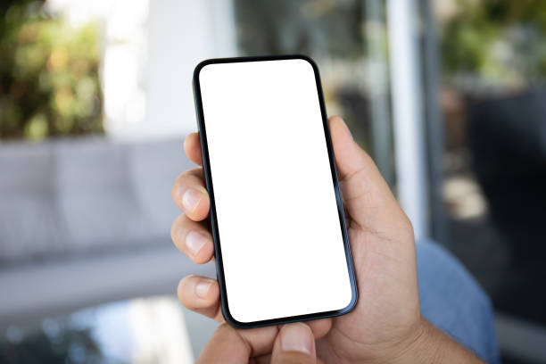 istock Male hands holding phone with screen isolated in office 2153426304