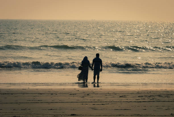 couple enjoying a romantic moment by the sea with the sunset in the background