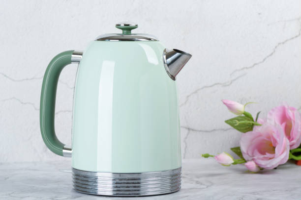 istock A green electric kettle and roses on the kitchen table. 2153429480