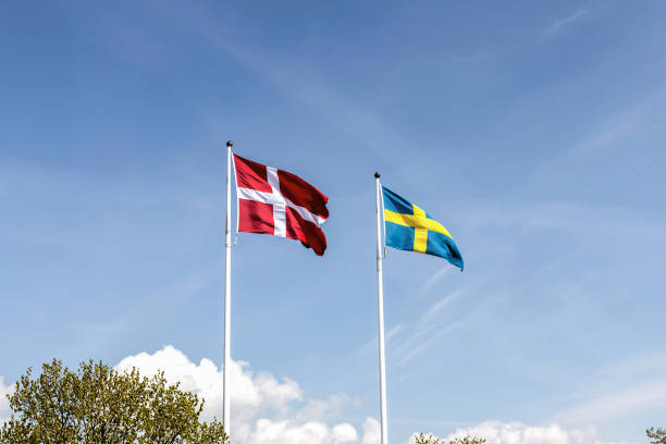 istock Denmark and Sweden flags against blue sky 2153433091