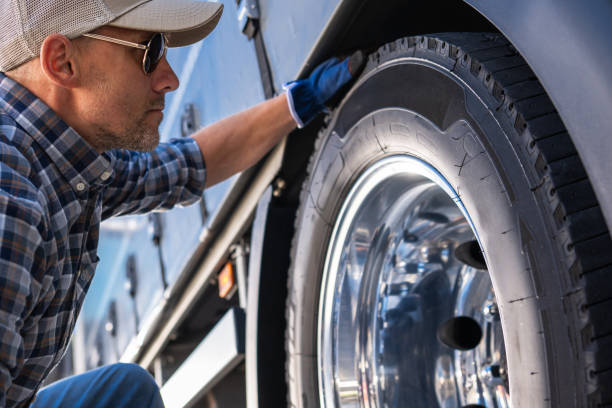 istock Trucker Examining a Tire on a Truck. 2153436810