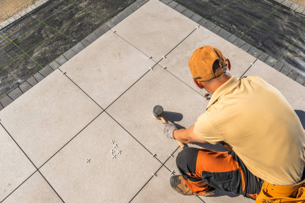 istock Man Laying Tile on Concrete Garden Patio Floor 2153437490