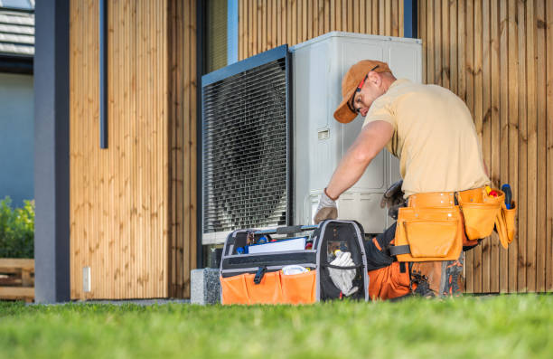 HVAC Technician Worker Fixing Heat Pump at House HVAC worker working on a modern heat pump outside a house. heat pump servieces  stock pictures, royalty-free photos & images