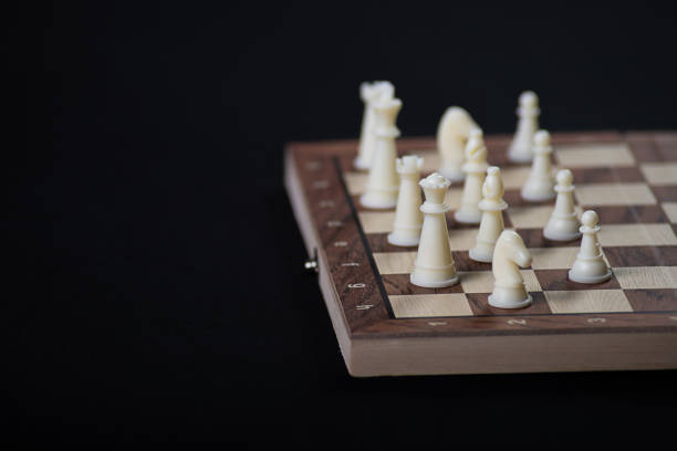 Chess board with light and dark pieces. Game concept. Board game. Hobby. Chess on the playing field for a game on a black background.
