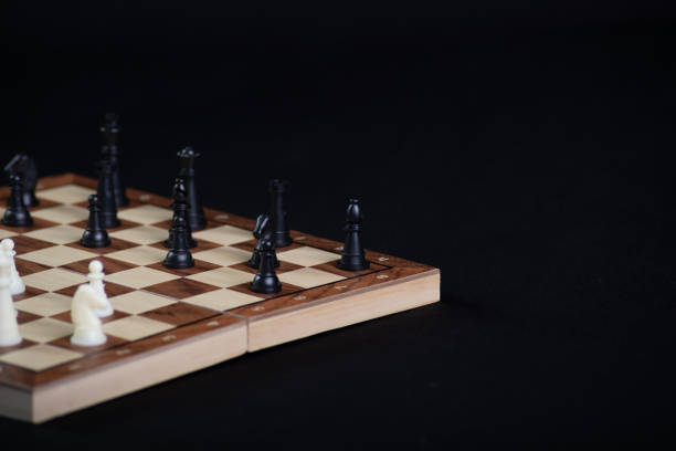 Chess board with light and dark pieces. Game concept. Board game. Hobby. Chess on the playing field for a game on a black background.
