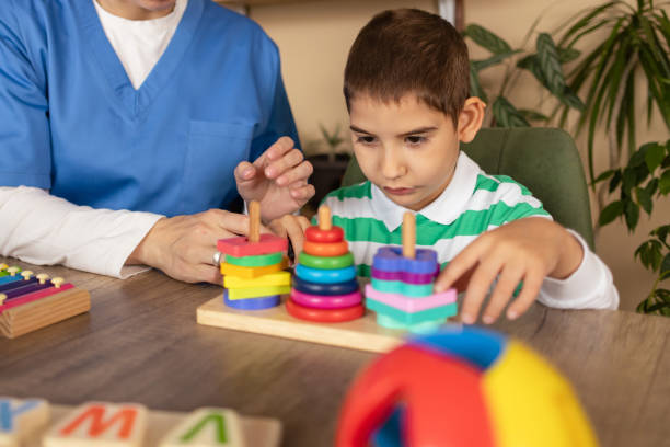 istock Nurse Engaging Boy with Autism in Sensory Play 2153445793