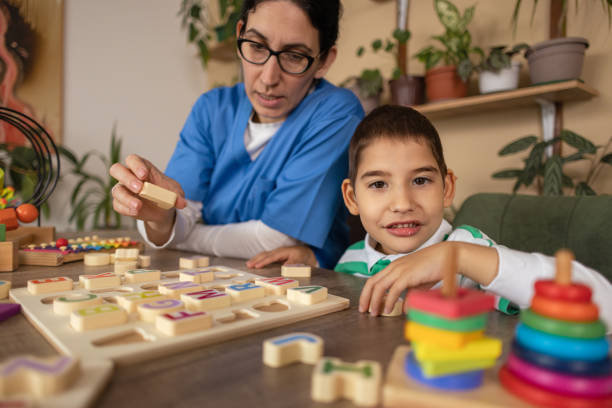 istock Nurse Helps Child with Autism Learn Alphabet 2153446424