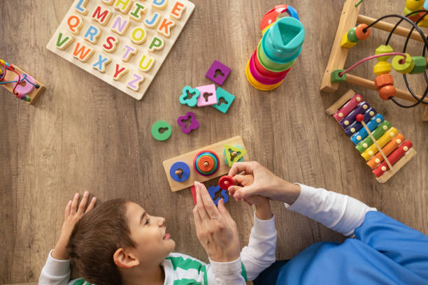 istock Nurse Assisting Child with Autism in Motor Skills Practice 2153446699