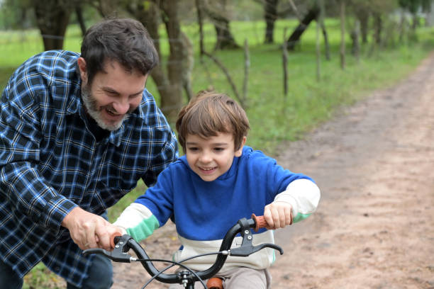 istock father teaching his son to ride a bicycle 2153447283