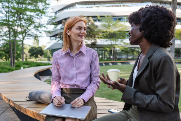 istock Two businesswomen having a conversation outdoors in park 2153447664