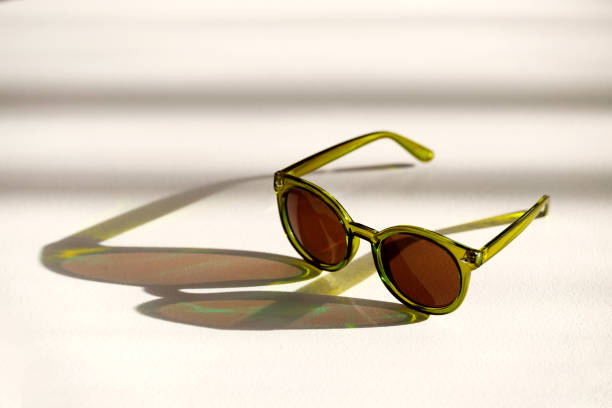 istock sunglasses lie on a white surface in the rays of the bright sun 2153451774