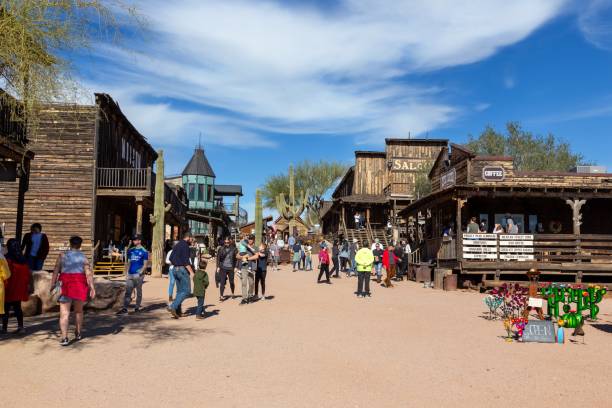 Apache Junction, Arizona, USA - December 24, 2023:  Tourists People Walking Down Historic Goldfield Ghost Mining Town Main Street with Replicas of Vintage Wild West Buildings