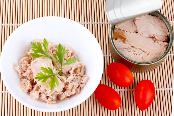 istock canned tuna in ceramic bowl isolated on bamboo mat top view 2153459127