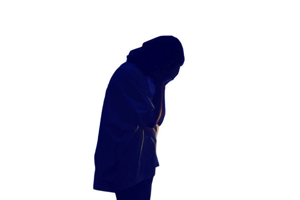 Woman crying at night dark window, low key silhouette, isolated on white background. The shadow of a sad female against the background