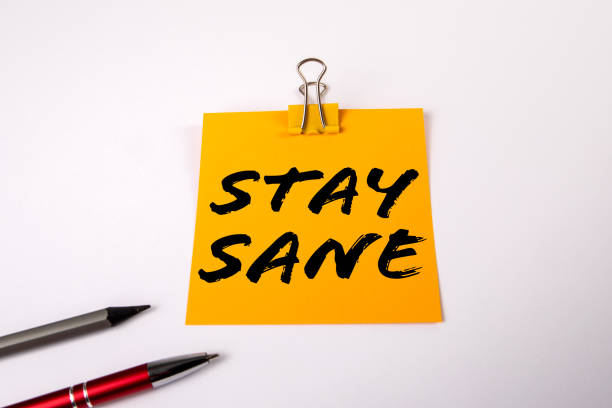 istock Stay Sane Concept. A yellow notepad on a white office table 2153462121