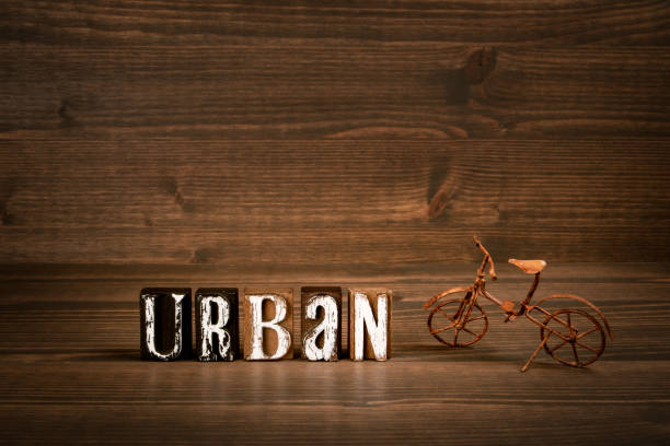 URBAN. Word from alphabet blocks and rusty miniature bicycle on wood texture background.