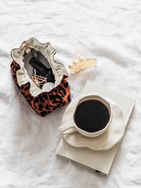 istock A cup of coffee, a notebook, a cosmetic bag on a light background, top view 2153465254