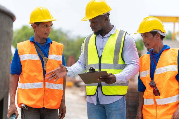 istock Foreman and workers team meeting for planning project at construction site, Site manager and builder control concrete mixer on construction site 2153467367