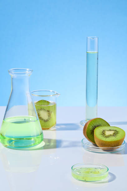 istock Creative photo for promotion was shot from front, the white flat against blue background with gradient effect, erlenmeyer flask and measuring cylinder with light green fluid and fresh kiwi 2153468394