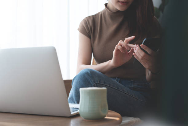 istock Young asian casual business woman using mobile phone and working remotely on laptop computer at coffee shop. Woman using smartphone for online shopping and payment via mobile app, social media 2153474951