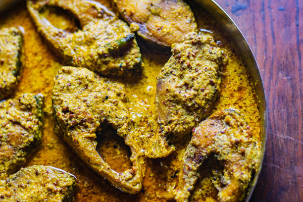 istock Sorshe ilish or hilsa fish curry cooked with mustard seeds. It is a very famous Bengali dish. Pieces of fish are seen in rich yellow gravy. This is traditional delicacy in Bengali culture. 2153475376