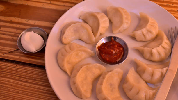istock Momos with hot red chutney served in white crockery. 2153479021