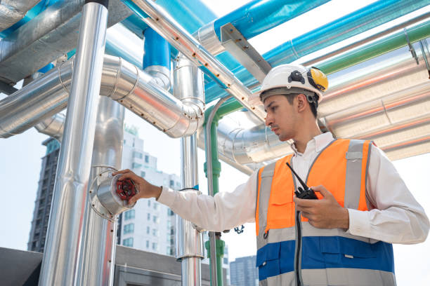 istock Portrait Asia male engineer in protective workwear is performing a conducts system check with use walkie talkie at rooftop building 2153479690
