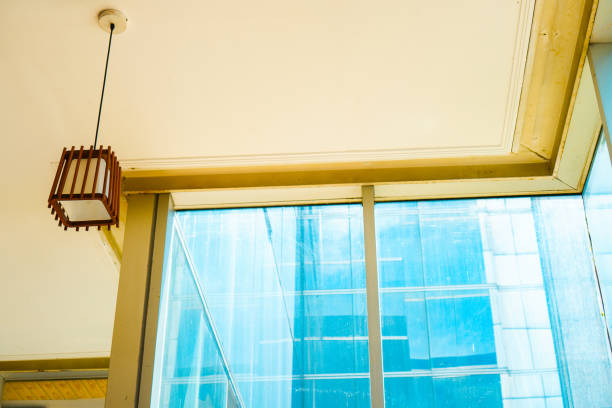 Graceful aesthetic chandelier against backdrop of towering glass window. captivating yellow and blue ambience fusion