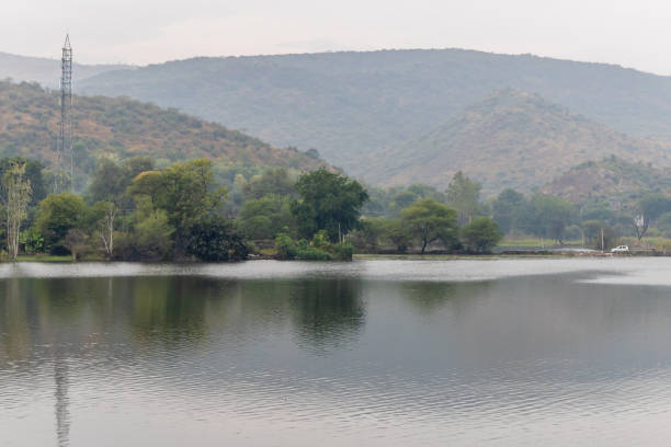 Hills with trees in the fog from a lake in JingYang, Sichuan Province, China