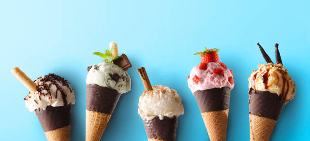 istock Five ice cream cones of various flavors on blue background 2153490112