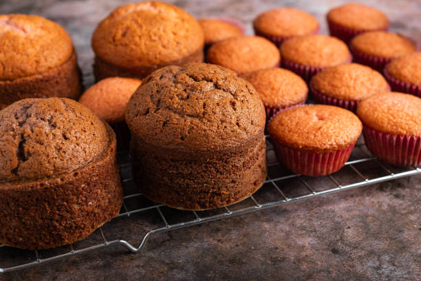 istock Small freshly baked cake and cupcakes in the background. Pastry table. 2153490664