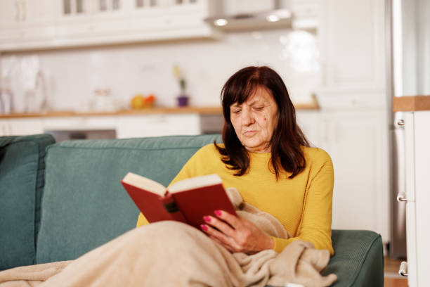 istock Senior woman reading a book at home 2153491909