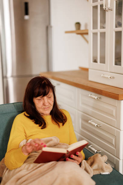 istock Senior woman reading a book at home 2153492338