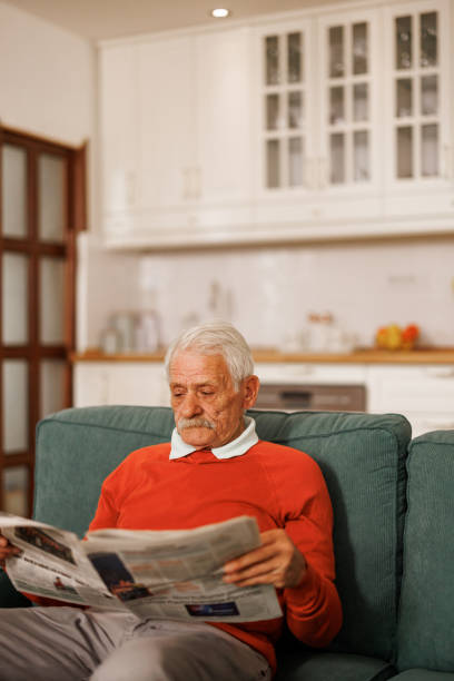 istock Senior man reading newspaper at home 2153492546