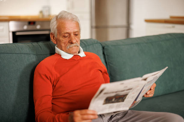 istock Senior man reading newspaper at home 2153493169