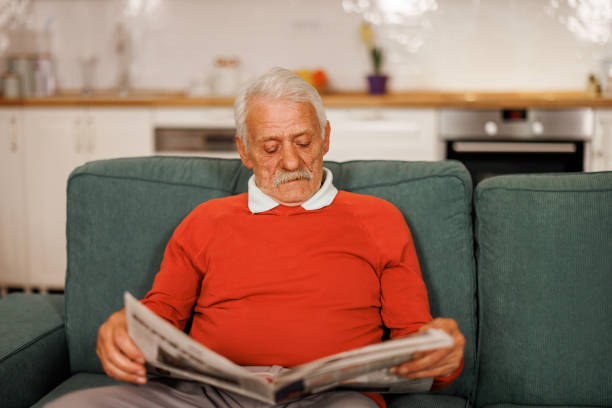 istock Senior man reading newspaper at home 2153493190