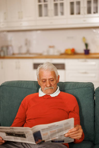 istock Senior man reading newspaper at home 2153493397