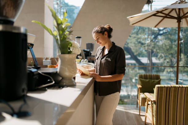 istock Beautiful woman checking the menu standing at cafe counter 2153501992