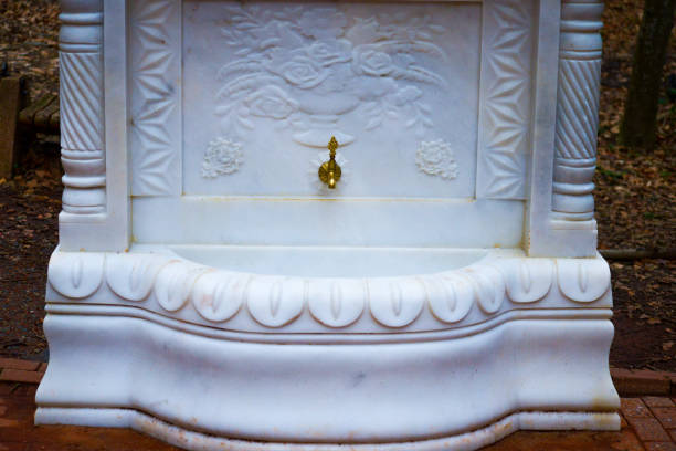 A luxurious golden fountain tap adorned with intricate white marble designs, exuding elegance and opulence.