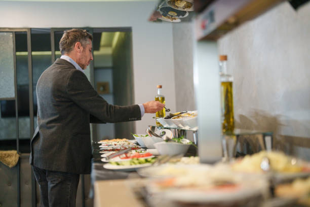 istock Businessman in self service breakfast room in hotel, preparing a plate. 2153514937