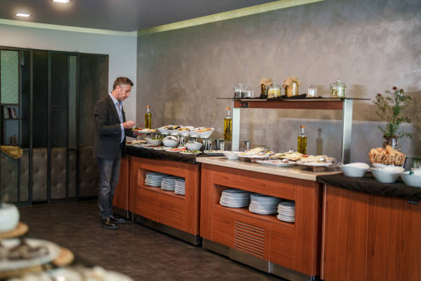 istock Businessman in self service breakfast room in hotel, preparing a plate. 2153516929