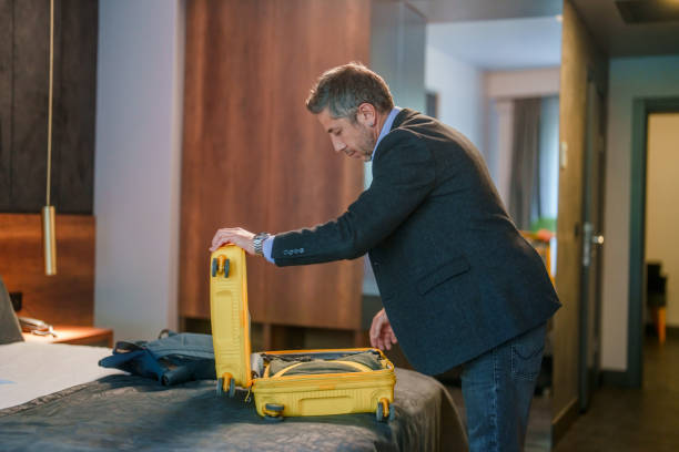 istock Businessman opening his suitcase on hotel bed. 2153521076