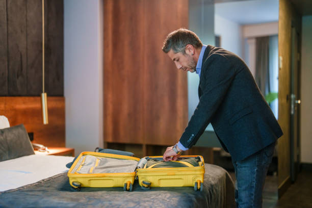 istock Businessman opening his suitcase on hotel bed. 2153521079