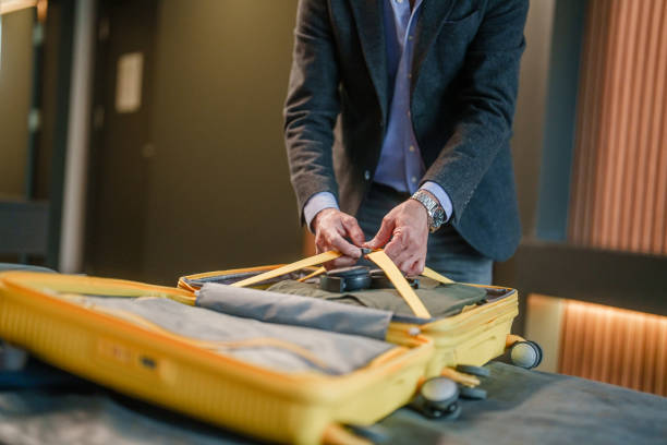 istock Businessman unpacking his suitcase on hotel bed. 2153521349
