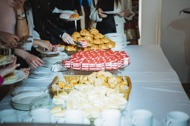 istock People gathered around a table sharing food at a social event 2153531857