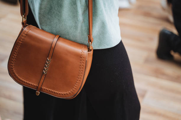 istock She is stylishly carrying a brown leather shoulder bag 2153532484