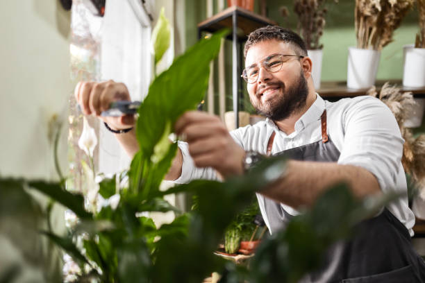 Young florist cutting leaves
