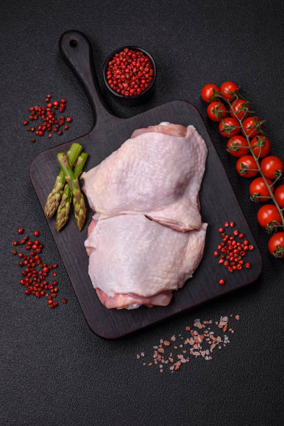 istock Raw chicken thighs with salt, spices and herbs 2153541652