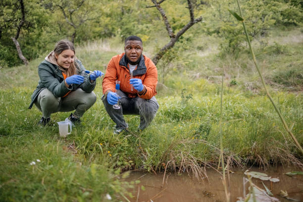 istock Young scientists doing research in nature taking a water sample from a lake 2153542549